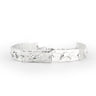 Handcrafted crescent charm bracelet in silver with textured moon accents.