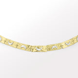A handcrafted bracelet with a 3D moon crescent charm and a patterned band, with tones of silver and gold.